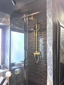 a bathroom with a shower with black brick walls at Midcoast Wohnung „THE BLACK“ in Nortorf +1 photo