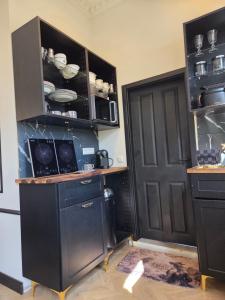 a kitchen with a black cabinet and a black door at Midcoast Wohnung „THE BLACK“ in Nortorf