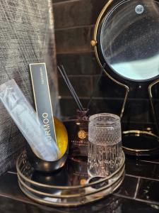 a table with a mirror and a glass and a bottle at Midcoast Wohnung „THE BLACK“ in Nortorf