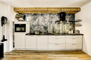 a kitchen with white cabinets and a white refrigerator at Das Bergnest Maishofen in Maishofen