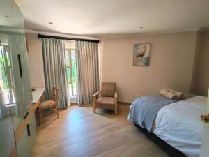 a bedroom with a bed and a desk and a chair at Pearl Vista in Somerset West +20 photos