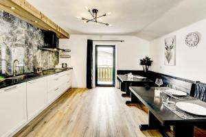 a kitchen with white cabinets and a dining table at Das Bergnest Maishofen in Maishofen +7 photos