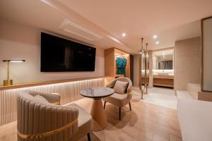a living room with a tv and a table and chairs at 신림 빌라드보니 villa de boni in Seoul
