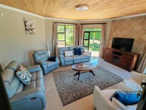 a living room with blue couches and a tv at Pearl Vista in Somerset West