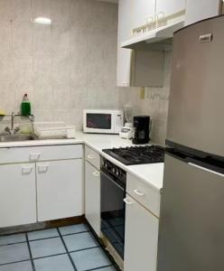 a kitchen with a refrigerator and a stove top oven at Tu depa en SLP in San Luis Potosí