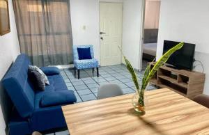a living room with a blue couch and a table at Tu depa en SLP in San Luis Potosí