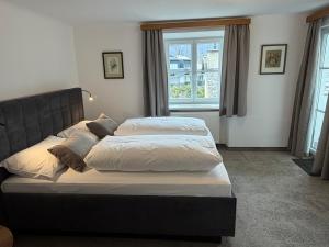 a bedroom with two beds and a large window at Pension Schiessling in Anif