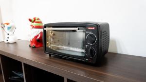 a black toaster oven sitting on a wooden table at Central and Comfortable Accommodation 4 in Altamira +8 photos