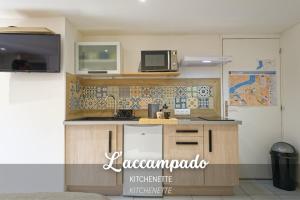 a kitchen with a counter top with a microwave at L'accampado in Arles