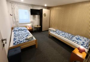 a small room with two beds and a window at Villa LIKE "garden-grill" in Bardejov