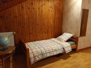 a bedroom with a bed and a wooden wall at Gîte "EN VALROMEY" au pied du Grand Colombier in Munet