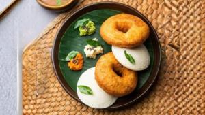 three donuts on a plate on a table at Rangoli Suites & Restrobar in Bantvāl