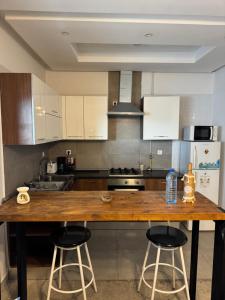 a kitchen with a wooden counter and two bar stools at L'œil de Fatma in Tunis +10 photos