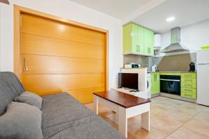 a living room with a couch and a table and a kitchen at Hauzify I Apartaments Bellaire in Blanes