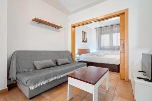 a living room with a couch and a bed at Hauzify I Apartaments Bellaire in Blanes
