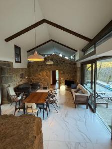 a living room with a table and a stone wall at Chalet con piscina Gondomar in Gondomar