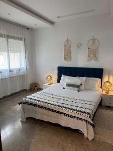 a bedroom with a large bed with a blue headboard at L'œil de Fatma in Tunis