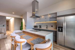 a kitchen with a table and chairs and a refrigerator at Hotel Time Oclock Medellin in Medellín