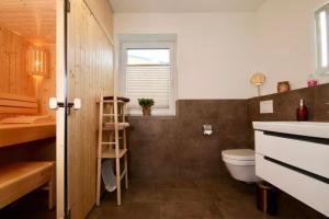 a bathroom with a toilet and a sink at Dahmer Strand 1 - LÜTT HUIS in Dahme +23 photos
