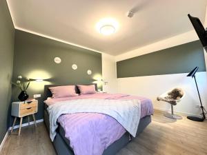 a bedroom with a large bed with a purple bedspread at Dahmer Strand 1 - LÜTT HUIS in Dahme