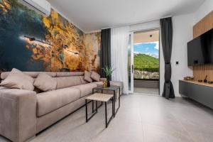 a living room with a couch and a large painting at Sunshine Breeze in Promajna