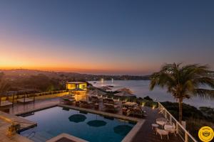 a swimming pool with a view of the water at Uni Boutique Hotel & Spa in Búzios