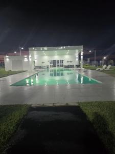 a building with a swimming pool at night at Kirara's House in Chanmico