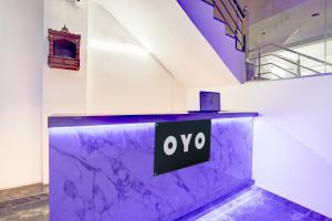 a lobby with a purple counter with a sign on it at HOTEL O SAMRAT INN in Prayagraj