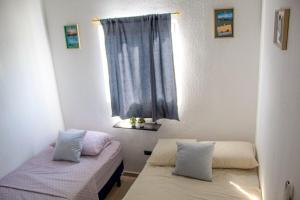 a bedroom with two beds and a window at Kirara's House in Chanmico