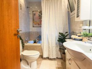 a bathroom with a toilet and a sink and a tub at Haplotēs Rhodes Studio in Koskinou