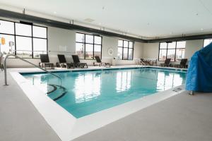 a large swimming pool with blue water in a building at Comfort Suites Effingham Central in Effingham