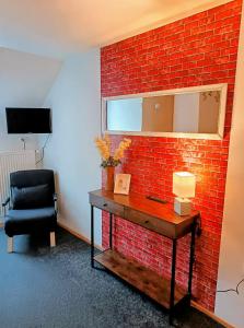 a room with a red brick wall and a chair at Villa LIKE "garden-grill" in Bardejov