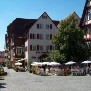 um grupo de mesas e cadeiras com guarda-sóis em frente a um edifício em Zum treuen Bartel em Markgröningen