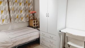a small bedroom with a bed and a dresser at Single Room near Science Park in Histon