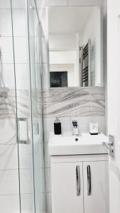 a white bathroom with a sink and a shower at Single Room near Science Park in Histon