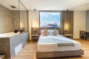 a bedroom with a large bed and a bath tub at Hotel Time Oclock Medellin in Medellín +121 photos
