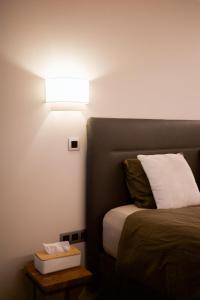 a bedroom with a bed with a light on it at Guesthouse Max in Burcht +11 photos