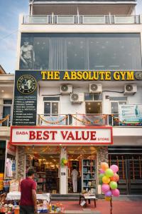 a man standing in front of a best value store at Absolute hostel in Meerut