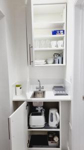 a kitchen with white cabinets and a sink in it at Single Room near Science Park in Histon