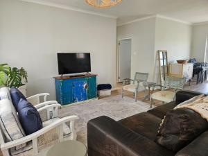 a living room with a couch and a flat screen tv at Graatjie in Kleinmond