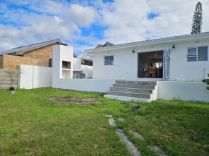 a white house with stairs and a yard at Graatjie in Kleinmond