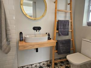 a bathroom with a sink and a mirror at Graatjie in Kleinmond +10 photos