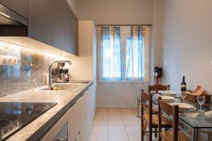a kitchen with a sink and a table with chairs at Artemida Beach Apartment 2 in Artemida