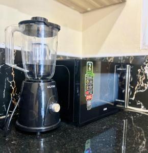 a blender sitting on a counter next to a microwave at Guest Favorite 1BDR with Washer, Netflix, Parking & Hot Shower 2547,96,065,022 in Mombasa