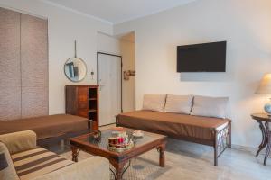 a living room with two beds and a tv at Artemida Beach Apartment 2 in Artemida