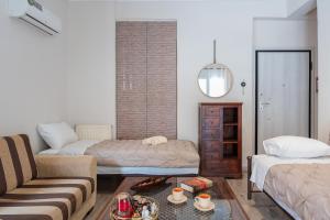 a living room with two beds and a couch at Artemida Beach Apartment 2 in Artemida