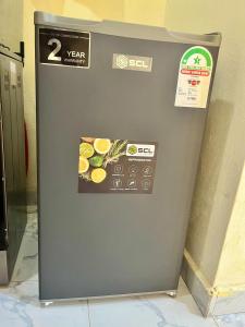 a gray refrigerator with stickers on the side of it at Guest Favorite 1BDR with Washer, Netflix, Parking & Hot Shower 2547,96,065,022 in Mombasa