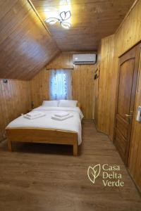a bedroom with a bed in a wooden room at Casa delta verde in Mahmudia
