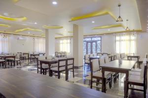 a restaurant with tables and chairs in a room at Hotel Pushkar Legacy in Pushkar