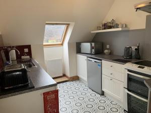 a small kitchen with a sink and a stove at Achmore Self catering in Stromeferry